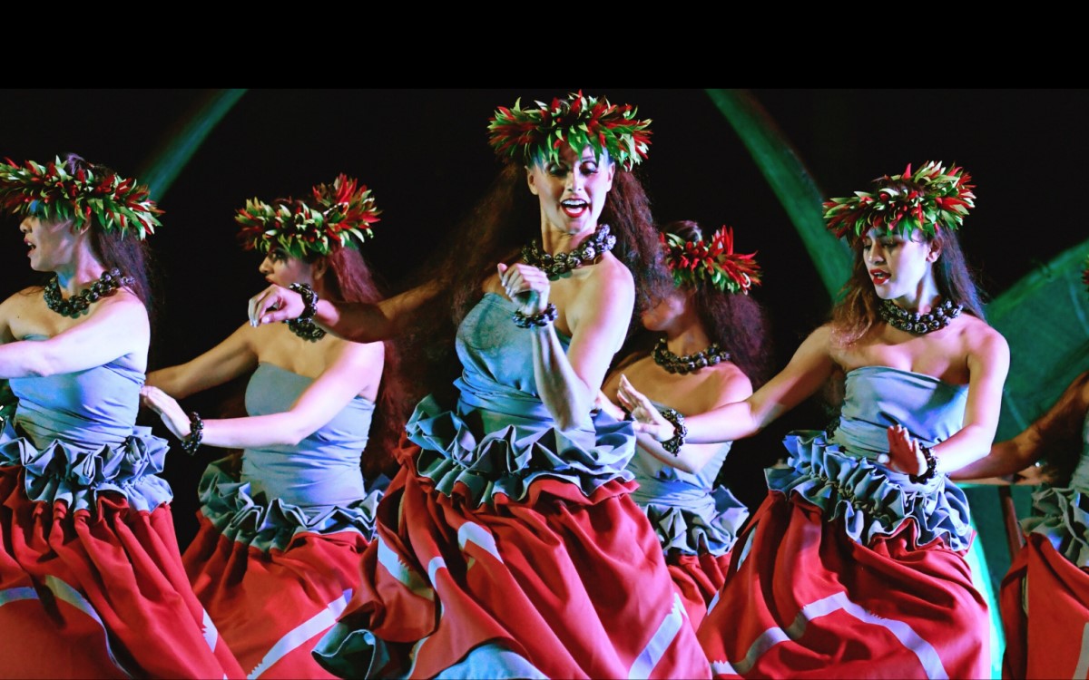 Dancers with flower headpieces performing at Ka Waa Luau