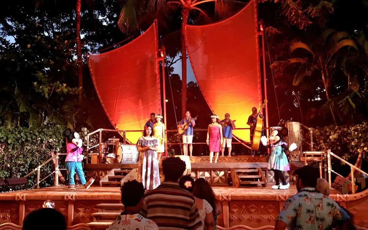 The canoe sail stage at Ka Waa Luau at Aulani lit red during the evening performance