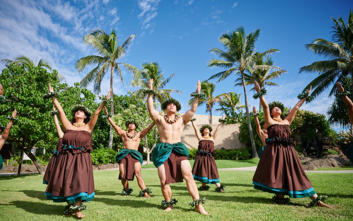 Dancers performing on the lawn at the Polynesian Cultural Center under a bright sky