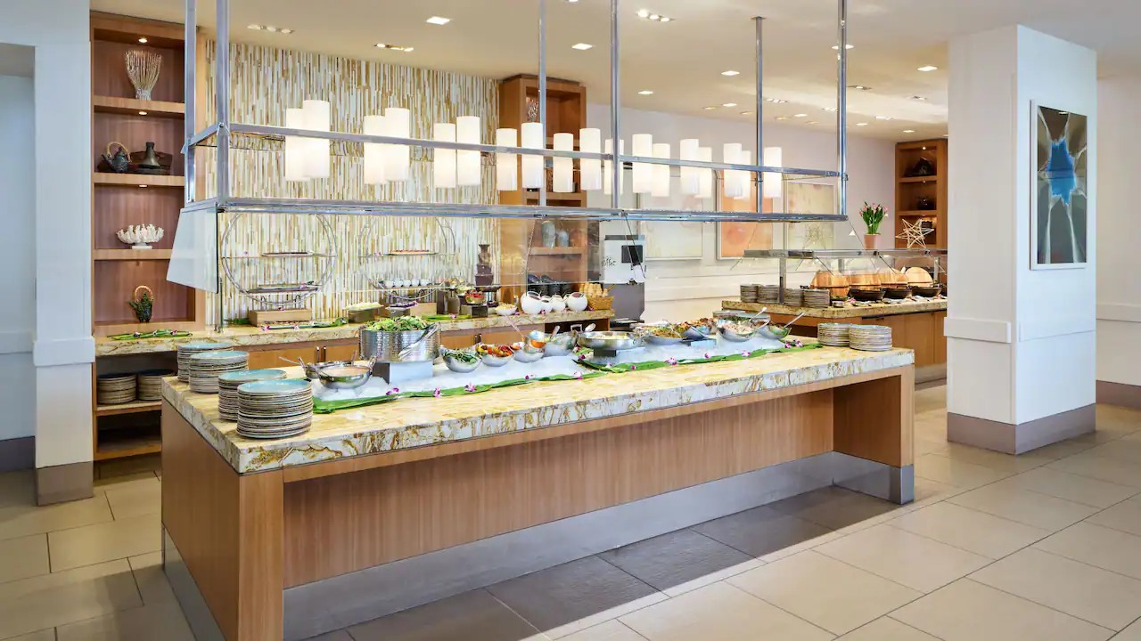 The buffet counter at The Buffet at Hyatt, laid out on a stone-topped island under pendant lights