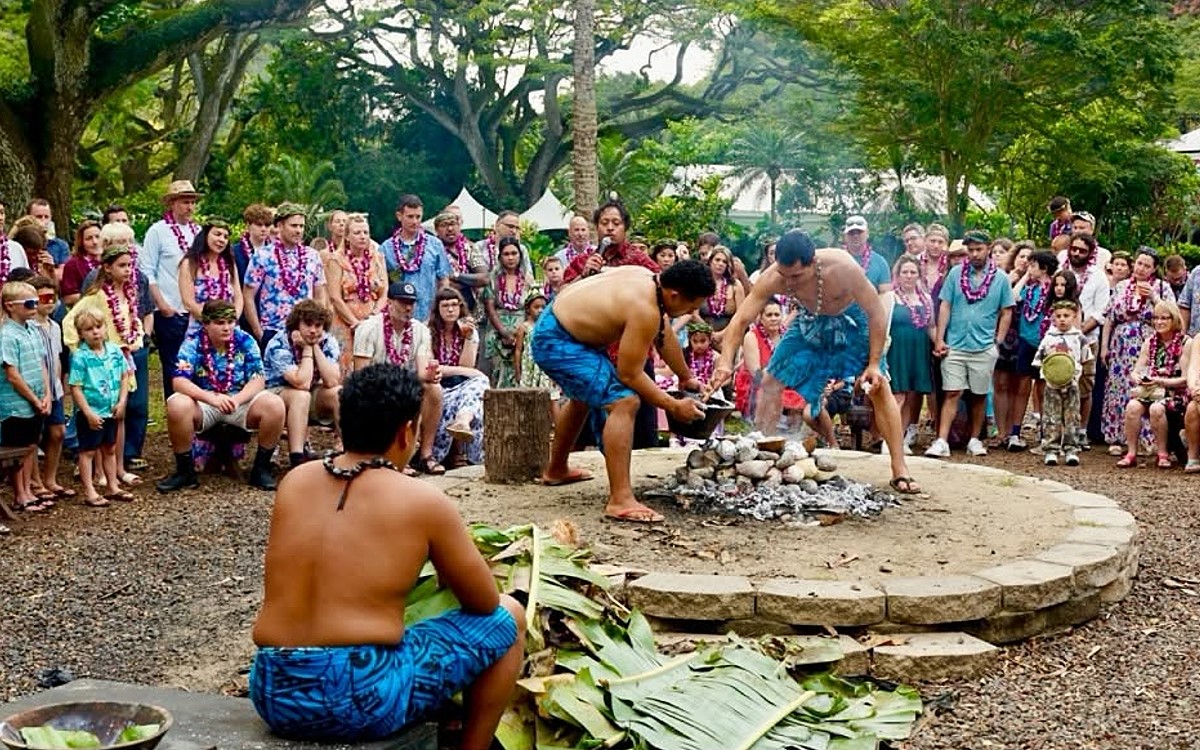 The imu demonstration at Toa Luau, guests gathered around the stone pit in Waimea Valley
